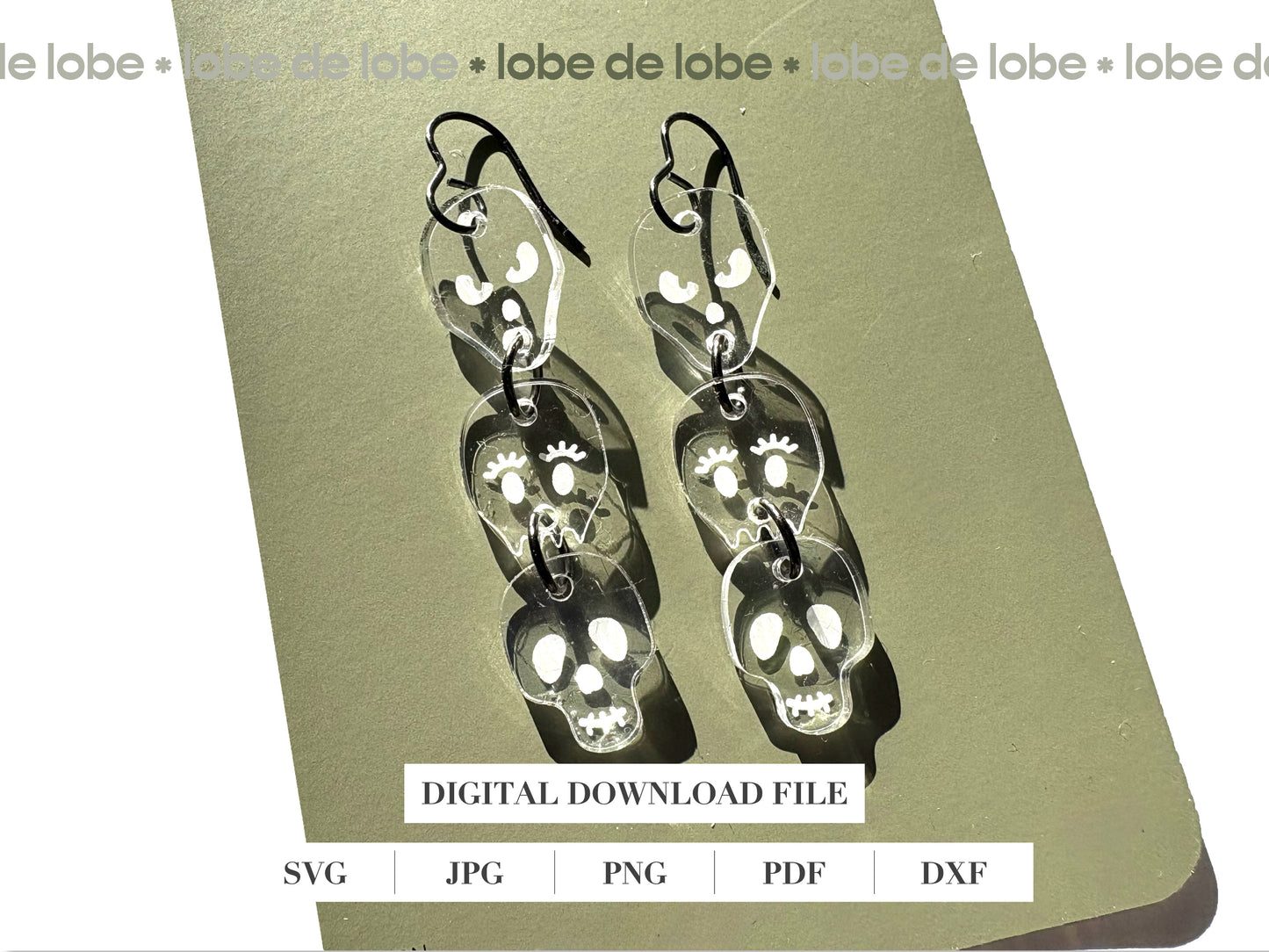 Pair of 3 dangling, transparent skull-shaped earrings.