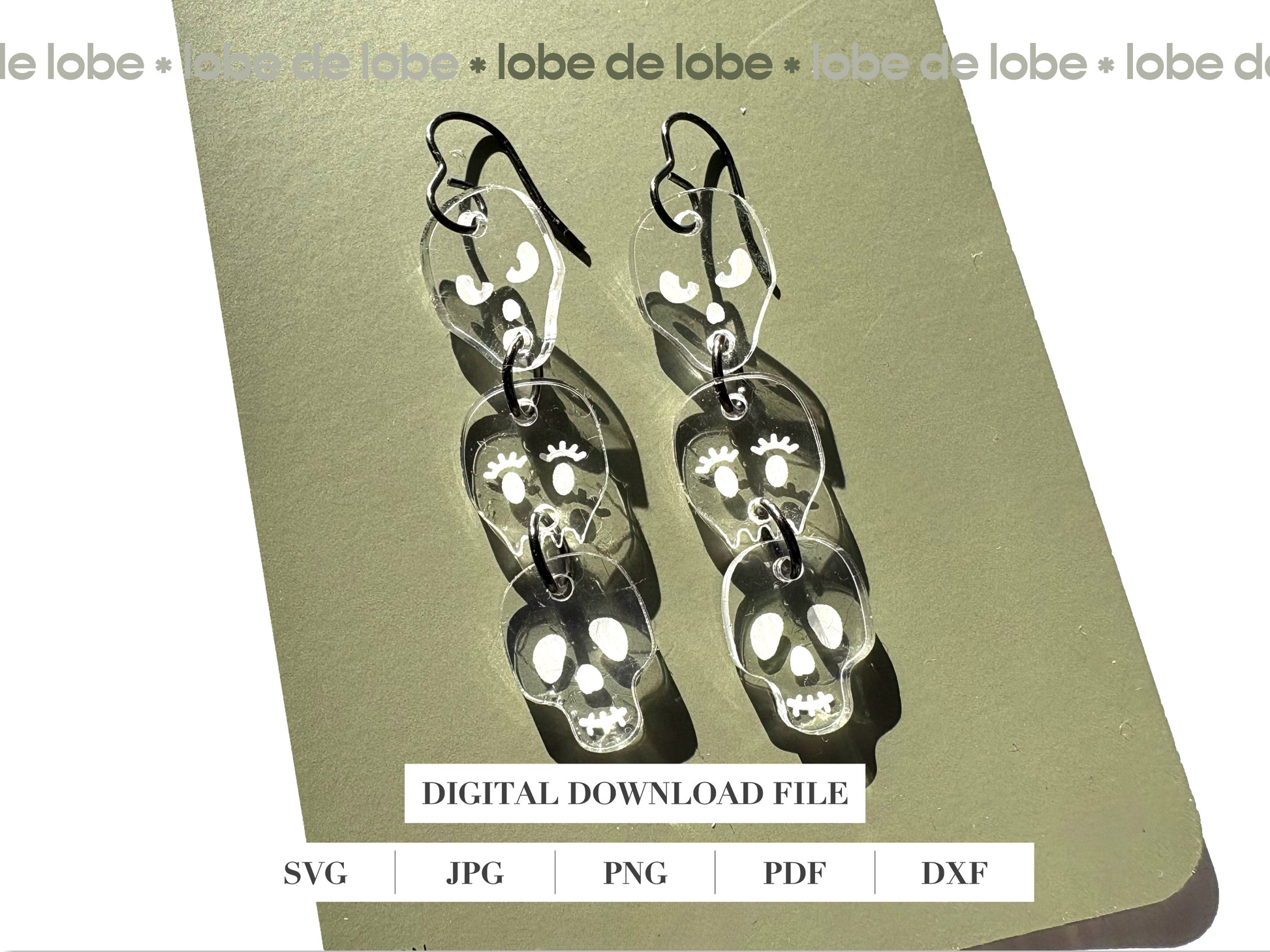 Pair of 3 dangling, transparent skull-shaped earrings.