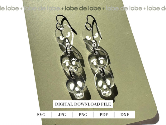 Pair of 3 dangling, transparent skull-shaped earrings.