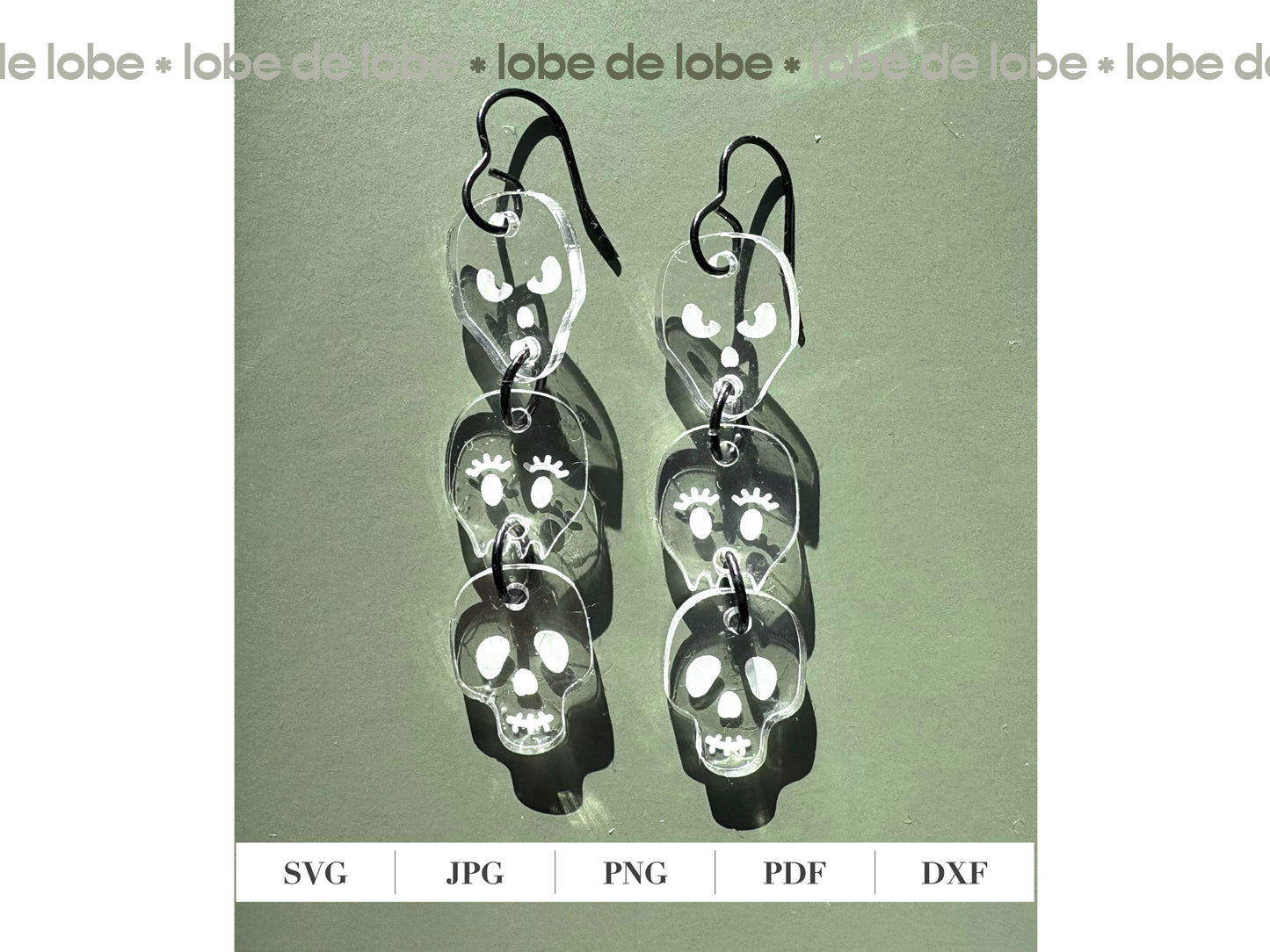 Pair of 3 dangling, transparent skull-shaped earrings.