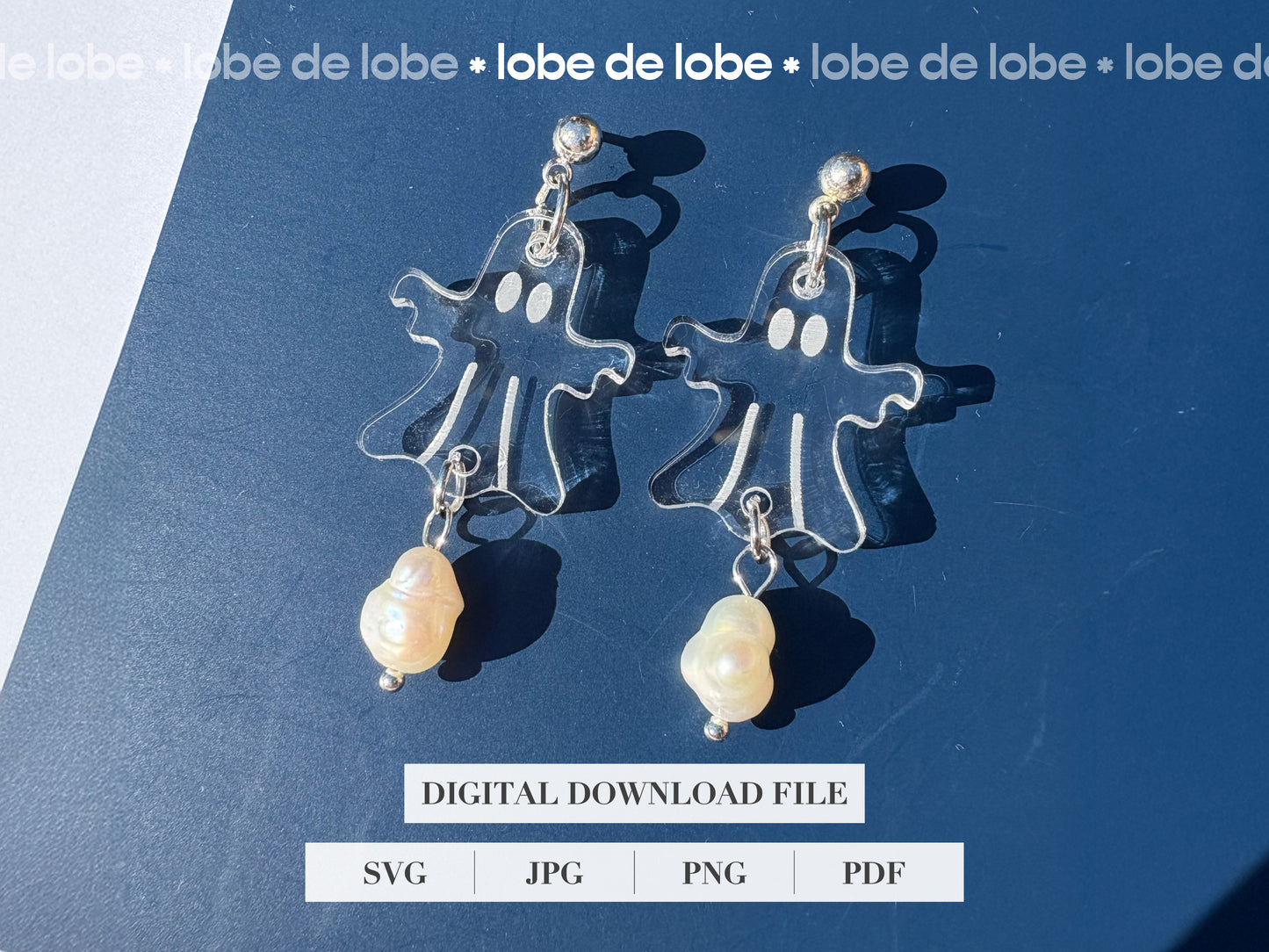 Pair of laser cut and engraved ghost earrings with pearls on a blue background.