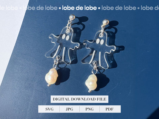 Pair of laser cut and engraved ghost earrings with pearls on a blue background.