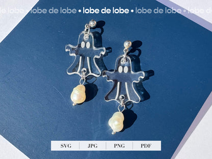 Pair of laser cut and engraved ghost earrings with pearls on a blue background.